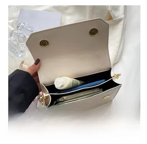 Internal compartments of white flap bag with magnetic closure and floral scarf detail