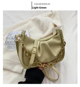 Detail of light green pleated dumpling bag with acrylic chain and gold hardware