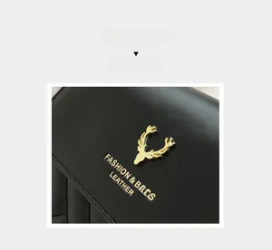 Detail of black leather crossbody bag featuring gold deer emblem and precision stitching