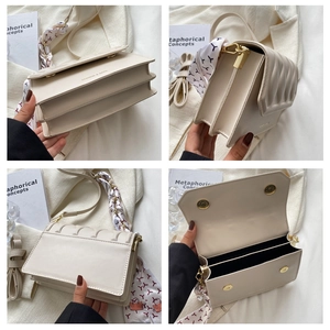 Detail view of cream quilted crossbody bag featuring interior layers and decorative scarf