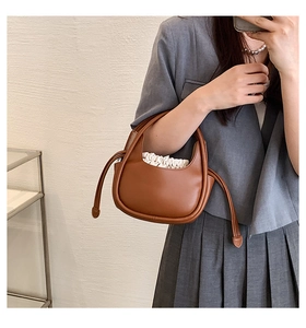 Détail d'un sac à main en cuir marron avec une doublure à cordon de serrage plissée