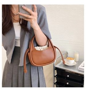 Selfie miroir montrant un sac à main en cuir marron avec pochette intérieure à cordon crème