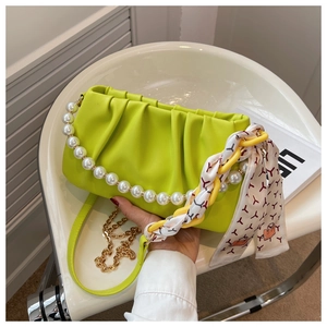 Close-up of lime green pleated cloud bag with pearl handle and silk scarf detail