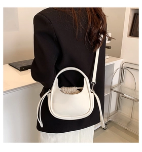 Détail du sac demi-lune blanc en cuir avec poignée incurvée et doublure à cordon