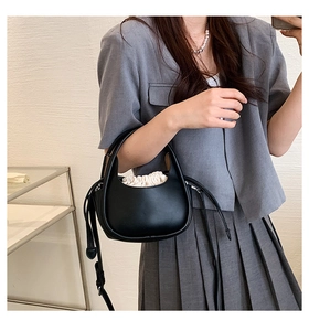 Détail du sac croissant noir avec pochette intérieure à cordon et glands en cuir chic