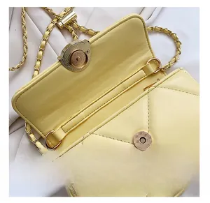 Détails du fermoir magnétique doré et des surpiqûres sur le sac en cuir jaune