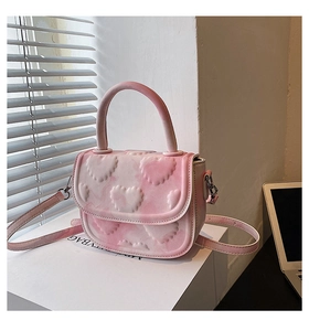 Vue détaillée du sac à main dégradé rose avec texture cœur en relief et boucles argentées