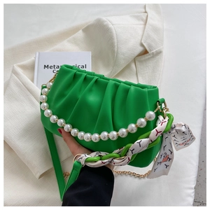 Detail of bright green pleated dumpling bag with pearl handle and silk scarf chain strap
