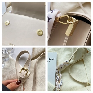 Detail of cream crossbody bag featuring magnetic buckle and silk scarf wrapped strap handle