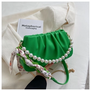 Close-up of bright green ruched cloud bag with pearl strap and silk scarf detail