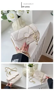 Détail d'un sac à bandoulière matelassé beige avec ferrures dorées et chaîne élégante