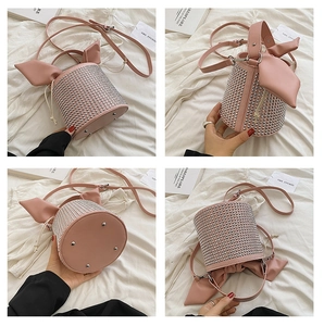 Close-up of pink bucket bag featuring silver rivets, bunny ear ribbons, and metal feet