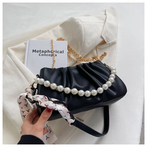 Detail of black pleated cloud bag with gold chain, pearl handle and floral silk scarf