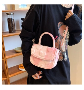 Détail du sac à main rose à motif de cœur avec bandoulière réglable et poignée chic