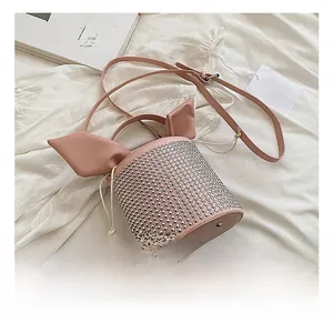 Pink bucket bag featuring silver rivets and rabbit ear flap detail on textured fabric