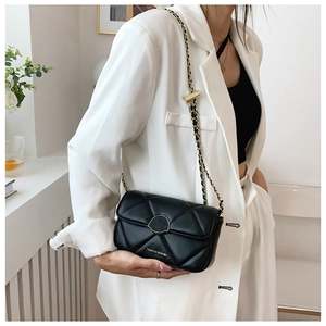 Vue détaillée d'un sac à bandoulière noir matelassé avec chaîne dorée et boucle ronde