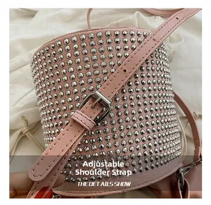 Close-up of adjustable pink shoulder strap with silver buckle on rhinestone bucket bag