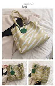 Detail view of cream yellow tote bag with white stripes and elegant flower charm