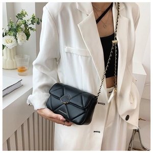 Détail du sac bandoulière matelassé noir avec chaîne dorée et fermoir sur un mannequin