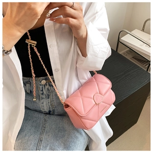Détail du sac à main matelassé rose avec bandoulière chaîne dorée et fermoir en métal