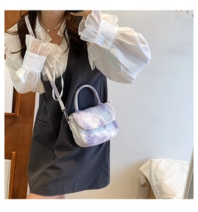 Détail du sac à main à motif marbre violet et blanc avec bandoulière en cuir réglable