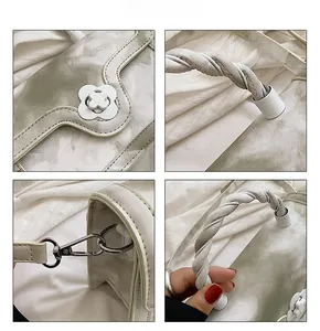 Detail of marble texture handbag featuring floral clasp and braided twist handle
