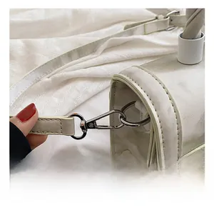Detail of silver metal lobster clasp and hardware on a marble pattern white handbag