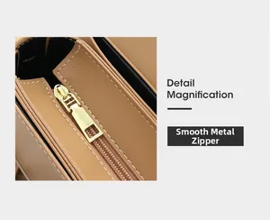 Macro view of light brown leather bag with white contrast stitching and smooth gold zipper