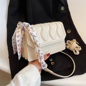 Chic cream-white crossbody bag with wavy quilting and silk scarf handle detail