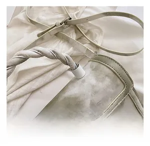 Detail of light green matte bag showing the unique twisted woven handle and hardware