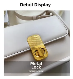 Détail du fermoir doré sur le cuir crème de ce sac à bandoulière de qualité