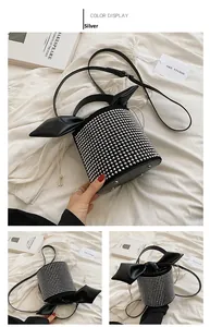 Close-up of black cylinder bucket bag with silver rhinestones and large bow detail