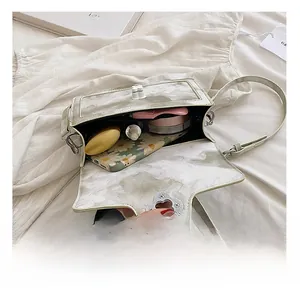 Internal capacity of marble pattern crossbody bag showing phone and cosmetics