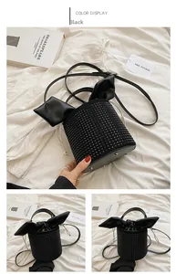 Detail of black rhinestone bucket bag featuring decorative leather ears and drawstring closure