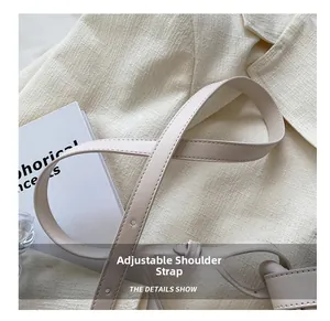 Détail d'un sac bandoulière crème en cuir avec bandoulière réglable et coutures fines