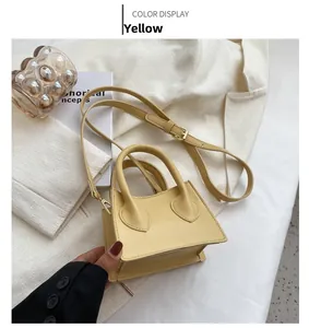 Vue détaillée d'un mini sac à main jaune en cuir sur un fond de blazer blanc élégant