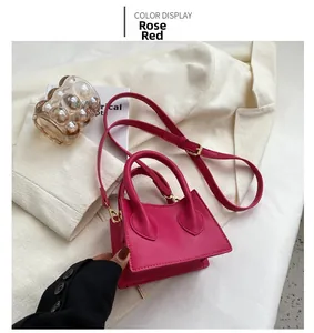 Détail d'un mini sac à main rose fuchsia en similicuir posé sur un blazer blanc élégant