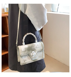 Detail view of small square bag with marble texture and white floral twist lock clasp