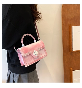 Detail view of pink marble pattern handbag with flower lock and braided top handle