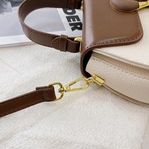 Detailed close-up showing the litchi grain texture and gold metal buckle of the square bag