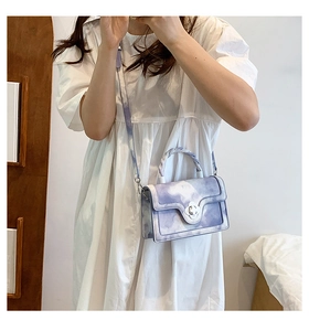 Detail of purple marble pattern bag with twisted handle and clover metal buckle