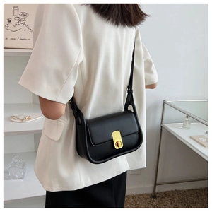Gros plan du sac bandoulière noir avec fermoir rotatif vertical doré très élégant