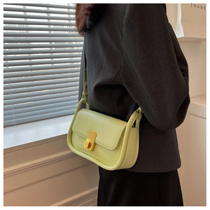 Détail du sac à bandoulière en cuir vert citron avec un fermoir en métal doré poli