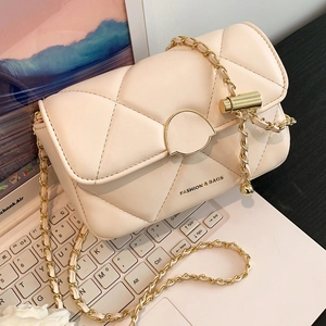Sac bandoulière matelassé beige minimaliste avec chaîne dorée sur fond d'ordinateur
