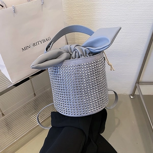 Chic light blue bucket bag with silver rhinestones and bow detail on a display shelf