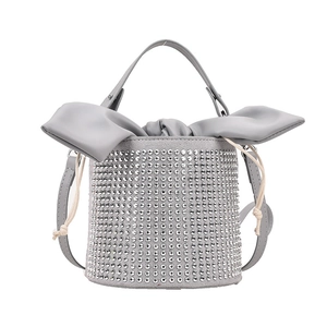 Sparkling grey rhinestone bucket bag with large leather bow detail and drawstring closure
