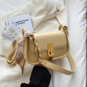 Petit sac à bandoulière beige chic avec foulard cerise et chaîne dorée sur fond blanc