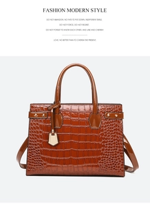 Detail view of brown crocodile-embossed leather tote with golden metallic studs