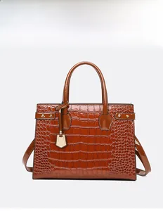 Polished brown crocodile embossed leather handbag with glossy finish and metal hardware detail