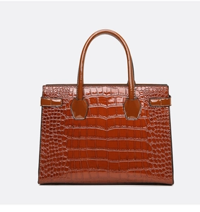 Detailed macro view of dark brown faux crocodile skin texture on luxury tote bag